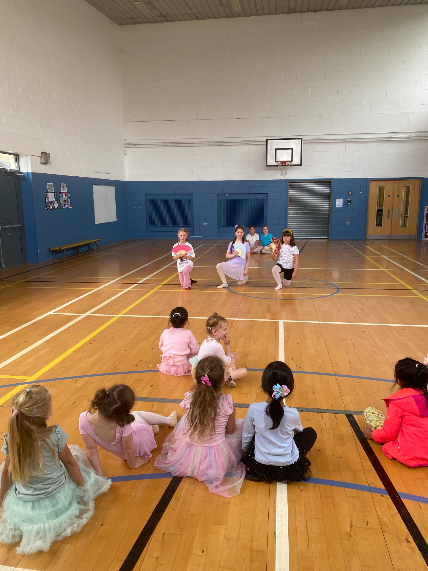 Young dancers at a ballet workshop with fans in the studio